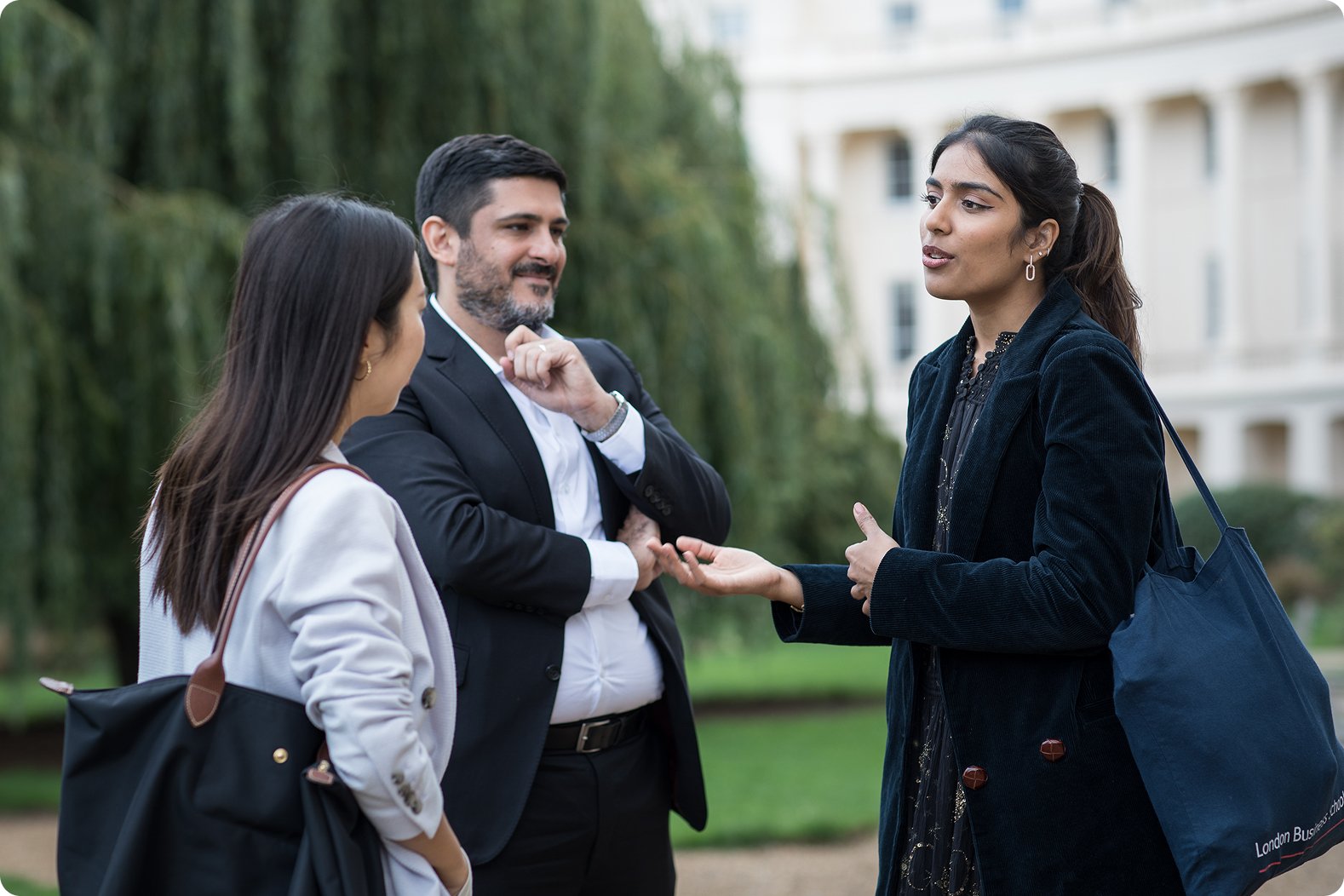 Three students conversing on campus